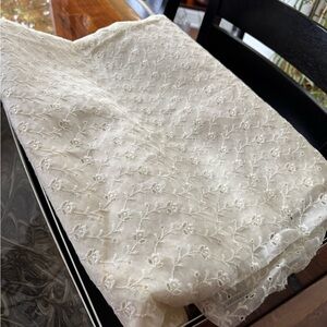 Shear cream colored fabric with floral embroidery detail